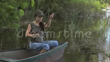 年轻女子渔夫正在森林湖上钓鱼，拿着鱼竿扭动着线圈。